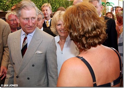 bikini clad woman greeting prince charles and his wife camilla