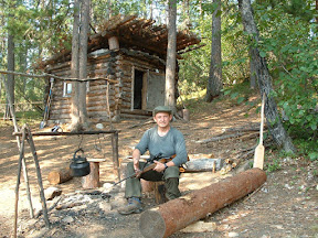 Ich posiere mit Wolodjas Gewehr vor der Jagdhütte.