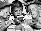 Brothers Paul (left) and Mike (center) Arms admire their prize baseball card collection with fellow card collector Robert Trupathy. August 28, 1965 USA